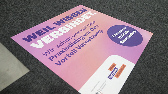 Ein Aufkleber auf einem Boden ist zu sehen. Darauf steht auf rosafarbenen Grund "Weil Wissen verbindet".